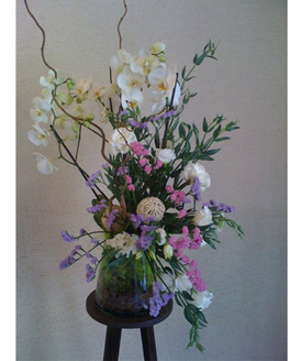 Un centro de diseo y buen gusto que incluye una planta de orqudea de 2 ramas  decorada y otras flores cortadas, con la posibilidad de aadir un peluche como regalo para el recin nacido.